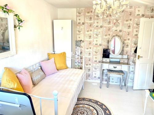 uma sala de estar com um sofá e um espelho em Happy Place with kitchenette- female only em Sydenham