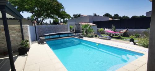 a swimming pool in the backyard of a house at Studio meublé et équipé avec jardin et terrasse privée in Beurlay