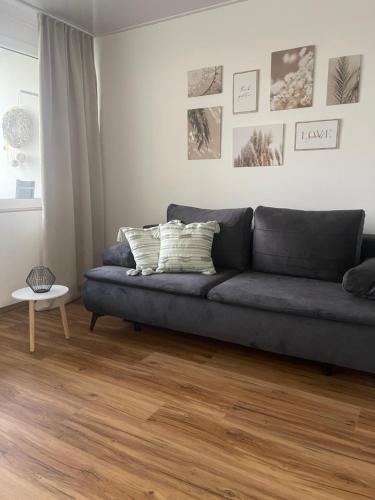 a living room with a blue couch and a wooden floor at See- und Bergblick Oberteuringen in Oberteuringen