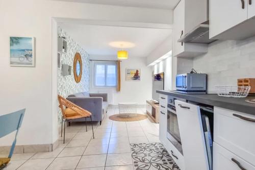 une cuisine et un salon avec un canapé dans l'établissement ROYAN - Villa La Cigale - 7 chambres / 16 couchages, à Royan