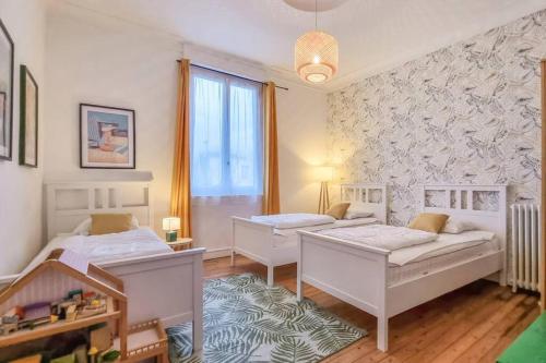 une chambre avec deux lits et une fenêtre dans l'établissement ROYAN - Villa La Cigale - 7 chambres / 16 couchages, à Royan