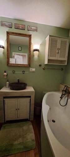 a bathroom with a tub and a sink and a mirror at 2 Rooms Apartment in old Town in Košice