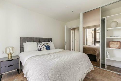 ein weißes Schlafzimmer mit einem großen Bett und einem Spiegel in der Unterkunft The Union in London