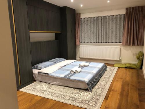 1 dormitorio con 1 cama grande con alfombra en 田园居 en Orpington