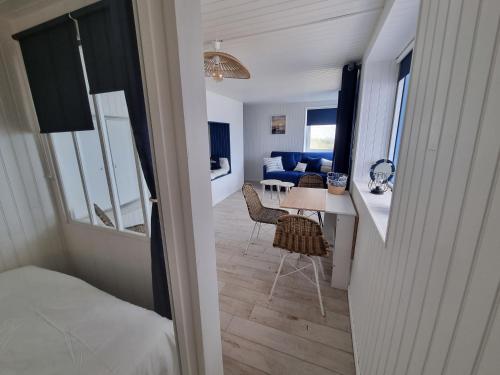 阿貢庫坦維爾的住宿－Petite maison avec jardin face mer，客房设有一张床和一张桌子及椅子