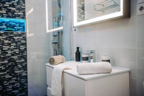 ein weißes Bad mit einem Waschbecken und einer Dusche in der Unterkunft Luxury Smart Apartman JJ in Szeged