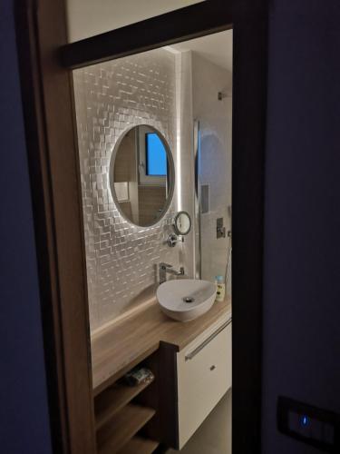 a bathroom with a white sink and a mirror at Apartma Bella Nadiža in Kobarid