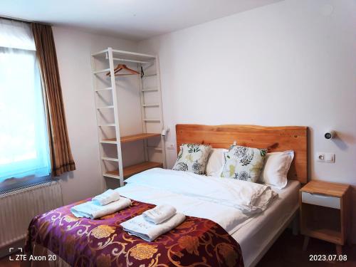 1 dormitorio con 1 cama con toallas en Pension Y&L, en Bled