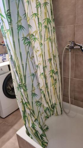 a shower curtain with a plant pattern on it in a bathroom at Apartman Mila in Belej