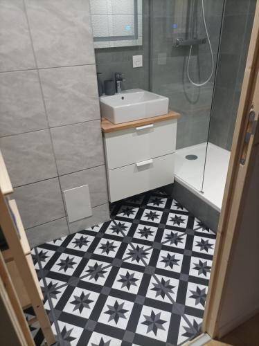 La salle de bains est pourvue de carrelage noir et blanc et d'un lavabo. dans l'établissement Sweet Home, à Mulhouse