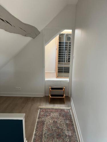 an attic room with a window and a rug at Les clos de Givry - Clos Théodore - Appartement 88m2 climatisé avec sauna et petite terrasse in Givry