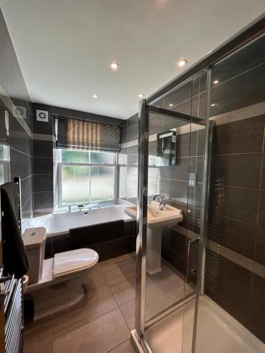a bathroom with a tub and a toilet and a sink at Luxury Apartment - Great Location in Ecclesall
