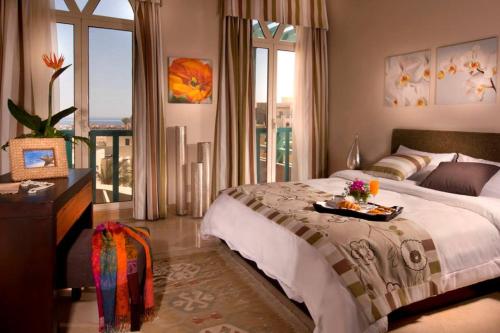a bedroom with a bed with a tray of food on it at Azzurra Sahl Hasheesh in Hurghada