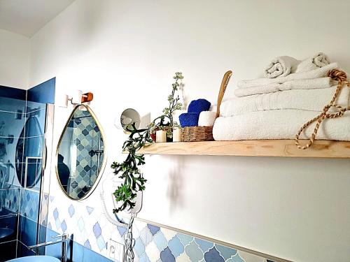 uma casa de banho com uma prateleira com toalhas e um espelho em Golden House em Porto Torres