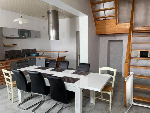 - une cuisine avec une table et des chaises blanches dans la chambre dans l'établissement Logement entier près de Mauleon.8/10 personnes, à Mauléon
