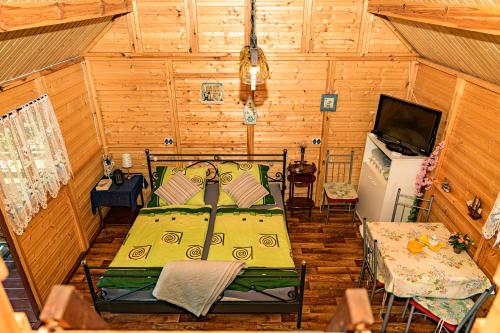 a bedroom with a bed and a television in it at domek na Mazurach in Gołdap