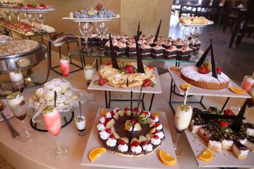 a table with many different types of cakes and desserts at O Beach Hotel & Resort in Sowayma