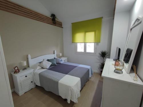 um quarto com uma cama, uma secretária e uma televisão em Dúplex Casa Ana Apartaclub La Barrosa em Chiclana de la Frontera