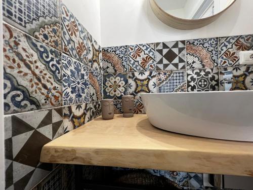 uma casa de banho com lavatório e azulejos na parede em L’angolo degli aromi em Ragusa