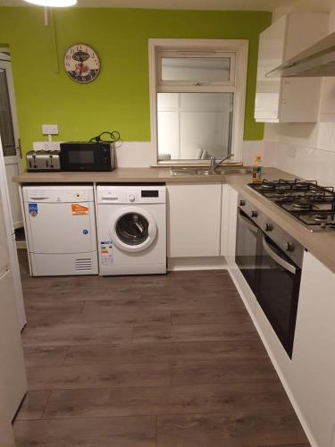 a kitchen with a washing machine and a stove at Wite in Colchester