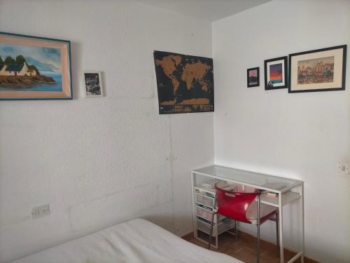 马德里FEMALE ONLY Pinar de Chamartin room的一间卧室配有一张床和一张红色椅子