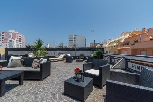 a patio with couches and tables on a rooftop at AL Barbinha in Faro