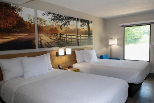 une chambre d'hôtel avec 2 lits et un tableau mural dans l'établissement Days Inn by Wyndham Farmville, à Farmville