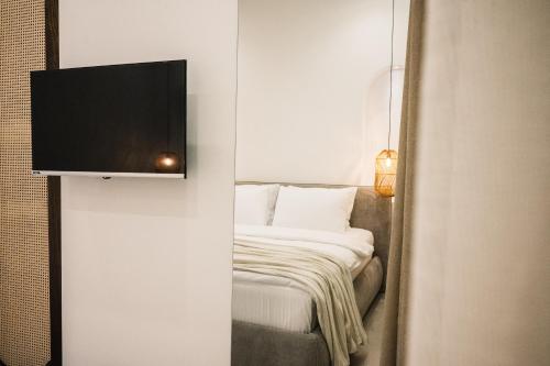 a bedroom with a bed and a television on a wall at KAAB Boutique Hotel in Ulcinj
