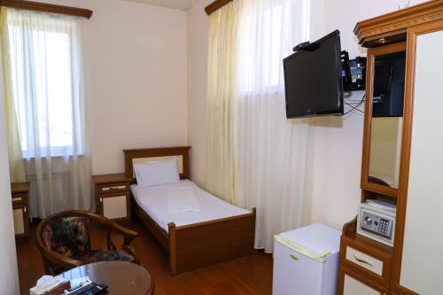 a small room with a bed and a tv at SD David Hotel in Yerevan