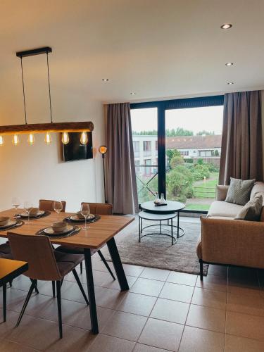 a living room with a table and a couch at Malpertus in Bredene