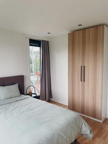 a bedroom with a large bed and a wooden cabinet at Malpertus in Bredene