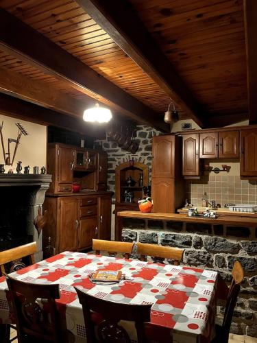 une cuisine avec une table avec une nappe rouge et blanche dans l'établissement Maison auvergnate, à Dauzat-sur-Vodable
