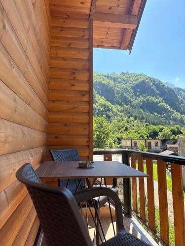 a patio with a table and chairs on a deck at Guest House Shtëpiza Theth in Theth