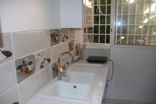 a kitchen with a white sink and a window at Appartement à 5 min de la plage in Bouéni