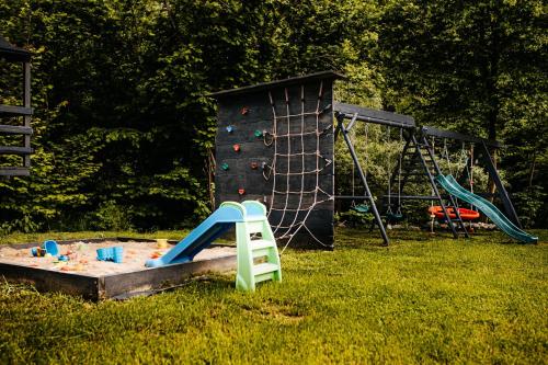 a playground with a slide and a climbing wall at Domki Nad Starym Potokiem in Ustrzyki Dolne