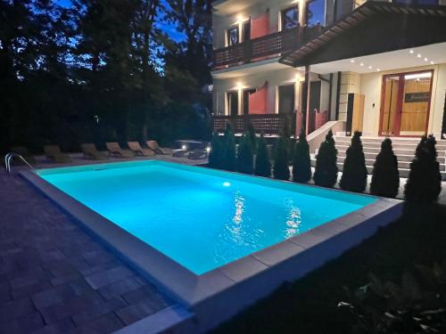 a swimming pool in front of a house at night at Diamond in Palić
