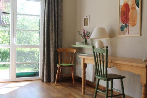 um quarto com 2 cadeiras, uma secretária e uma janela em Szwajcaria Mazurska em Zawady