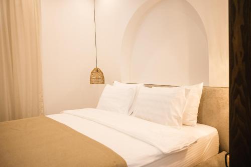 a bedroom with a bed with white sheets and pillows at KAAB Boutique Hotel in Ulcinj