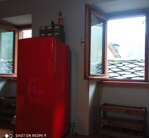 einen roten Kühlschrank in einem Zimmer mit 2 Fenstern in der Unterkunft Viottolo 12 Bike & Sky Room - Rosazza in Campiglia Cervo