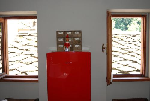 einen roten Kühlschrank in einem Zimmer mit 2 Fenstern in der Unterkunft Viottolo 12 Bike & Sky Room - Rosazza in Campiglia Cervo