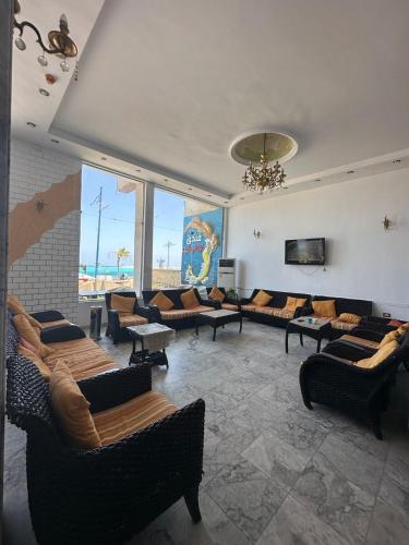 uma ampla sala de estar com sofás e um lustre em Aros Al Bahr Hotel em Marsa Matruh