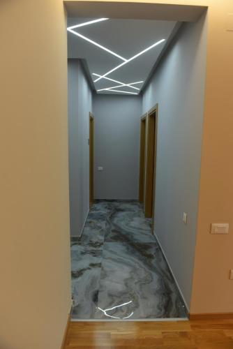 a hallway with a marble floor in an office building at Premium Lux Apartman Čačak in Čačak