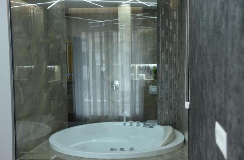 a bathroom with a bath tub with a glass shower at Premium Lux Apartman Čačak in Čačak