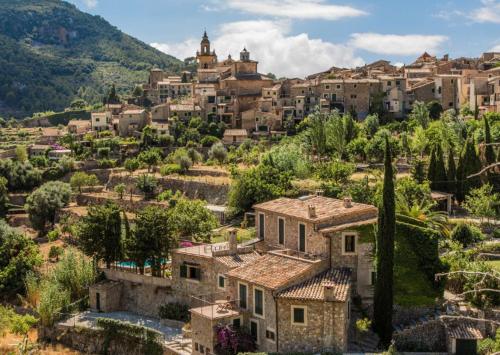 a village on a hill with houses and trees at Valldemosa Sleep & Hike in Valldemossa