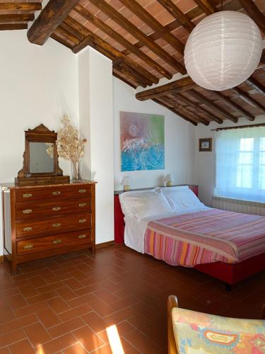 um quarto com uma cama, uma cómoda e uma televisão em La casa In Valli 35 em Bagni di Lucca