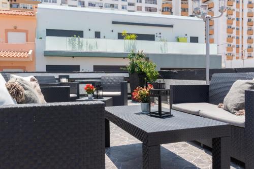 a patio with chairs and tables on a balcony at AL Barbinha in Faro