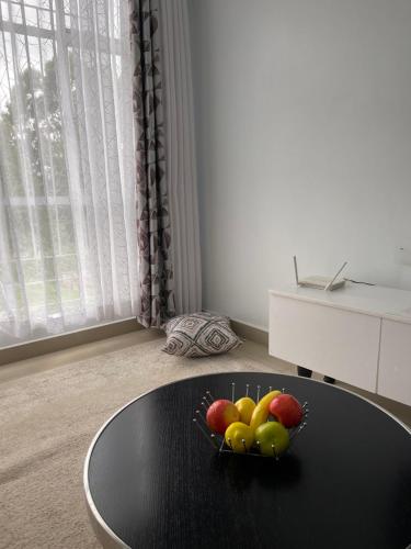 Kericho的住宿－Prime Nest Grey point 305，房间里的一碗水果放在黑桌上