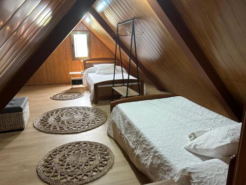 a attic bedroom with two beds and two rugs at CASA O PIÑEIRO in Redondela