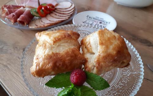 two pastries on a plate with a raspberry on a table at Romantik-Suite Nordelsaß B&B in Oberhoffen-lès-Wissembourg