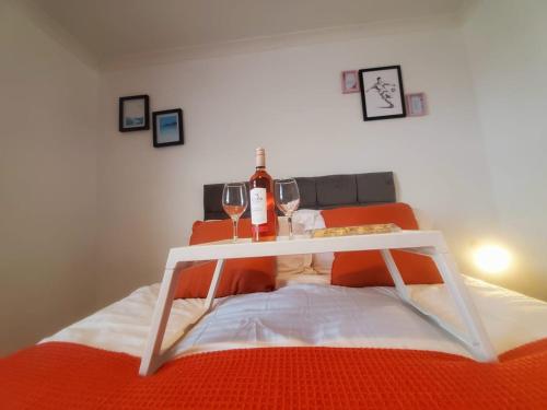 una mesa con dos copas de vino encima de una cama en Aqua Suite en Gillingham